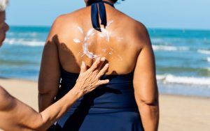 Duas mulheres que são amigas, estão passando o protetor solar Safe Sea para se proteger do sol